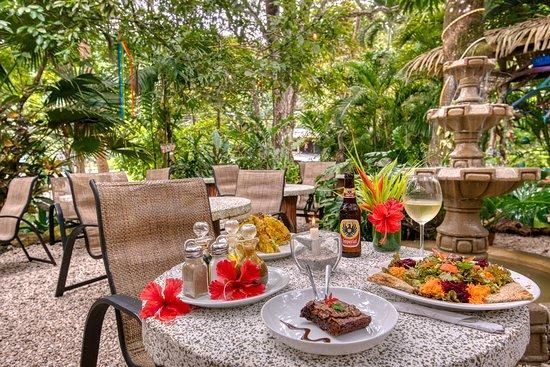 A table with plates of food and wine glasses on it.