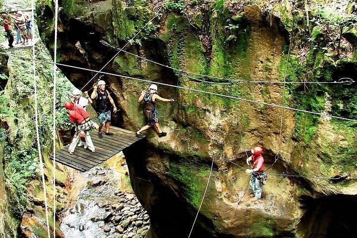 A group of people are standing on a bridge over a river.