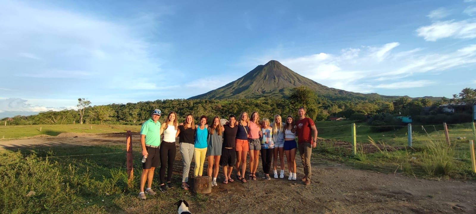 group of people standing in front of volcano