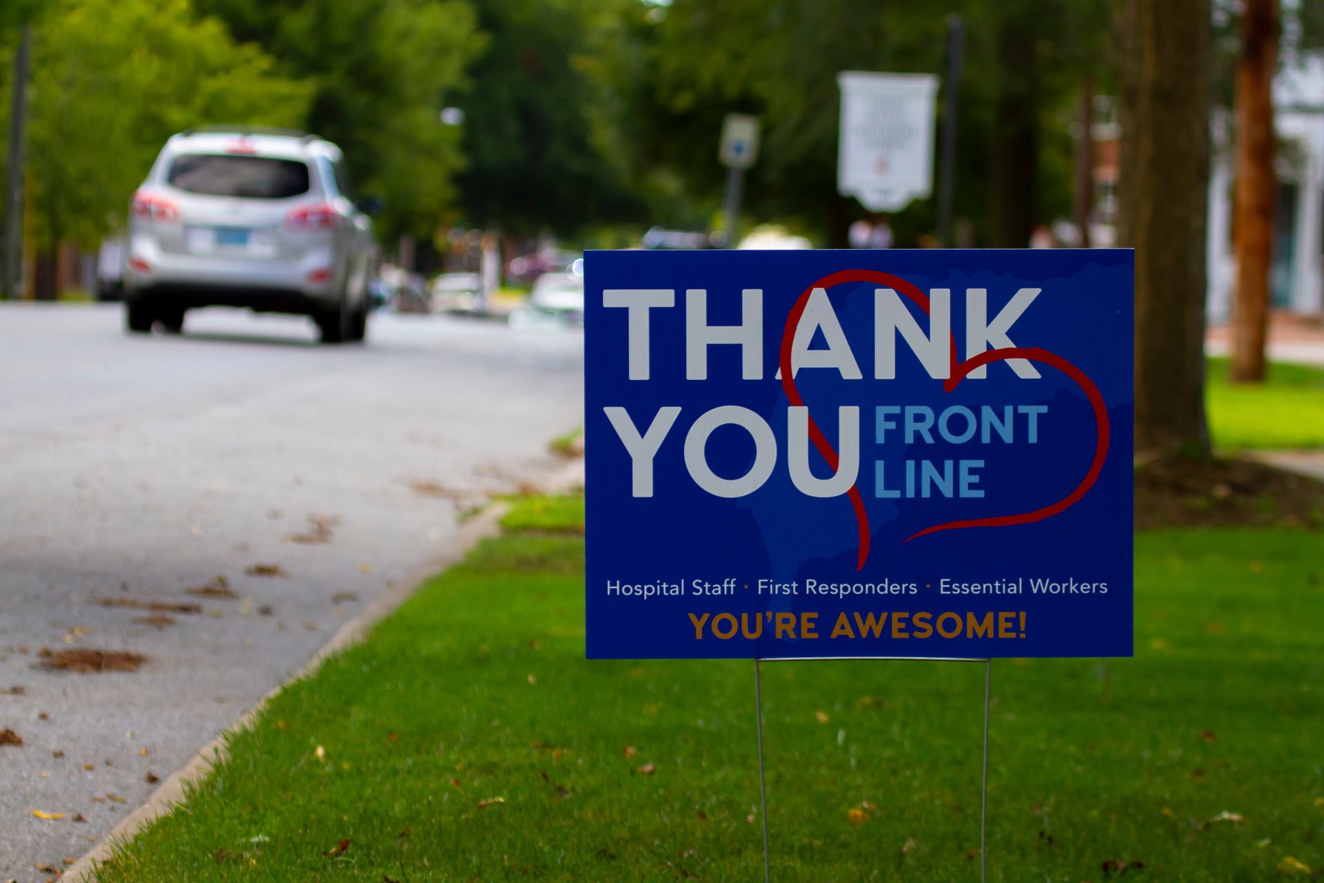A blue thank you sign is on the side of the road.