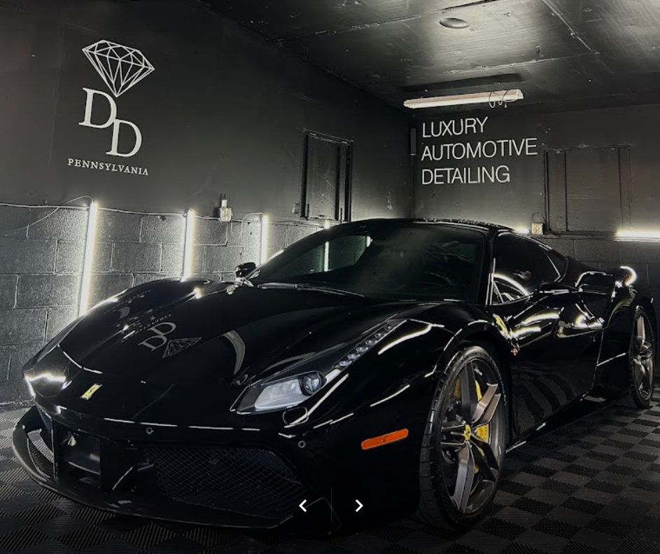 A black sports car is parked in a garage.