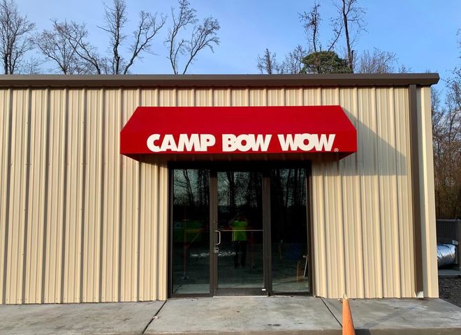 A building with a red awning that says camp bow wow