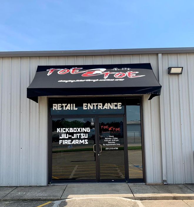 A store front with a black awning that says retail entrance