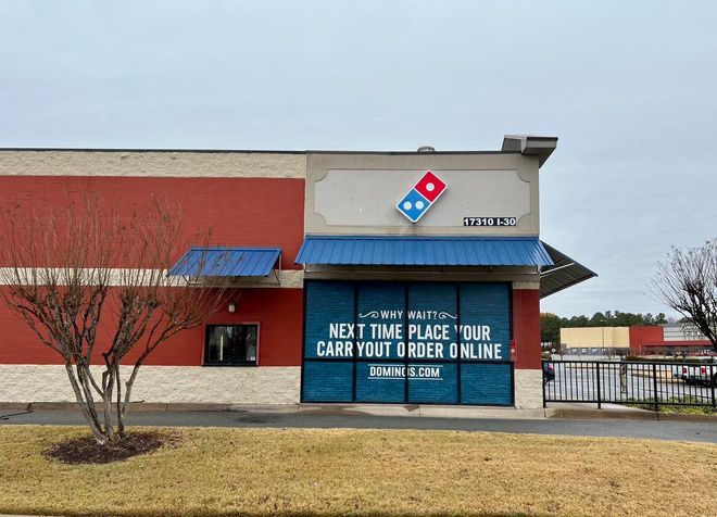 The front of a domino 's pizza restaurant with a sign that says `` next time place your carryout order online ''.