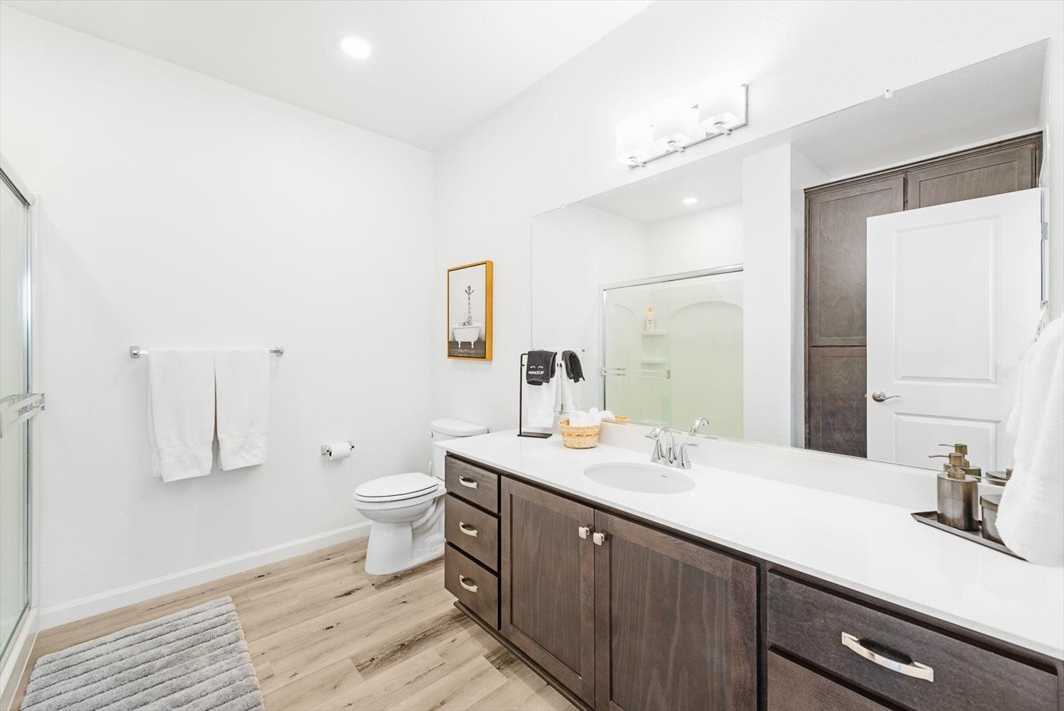 Modern bathroom with a double-sink vanity, toilet, and glass shower. See how The Silvergate fits your lifestyle.