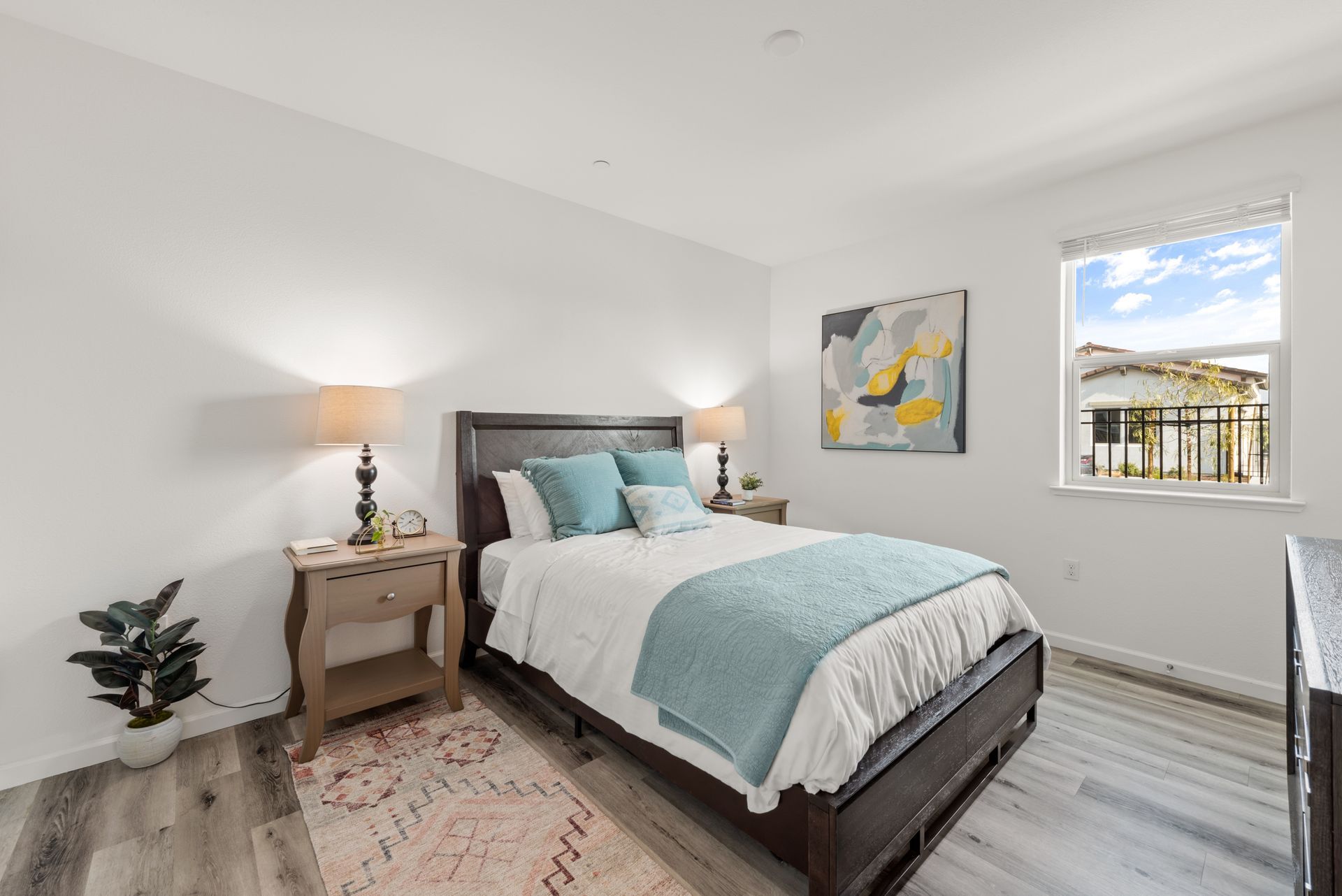 Bright bedroom with a dark wood bed, two nightstands, lamps, and a window. Get inspired by Brentwood at Silvergate.