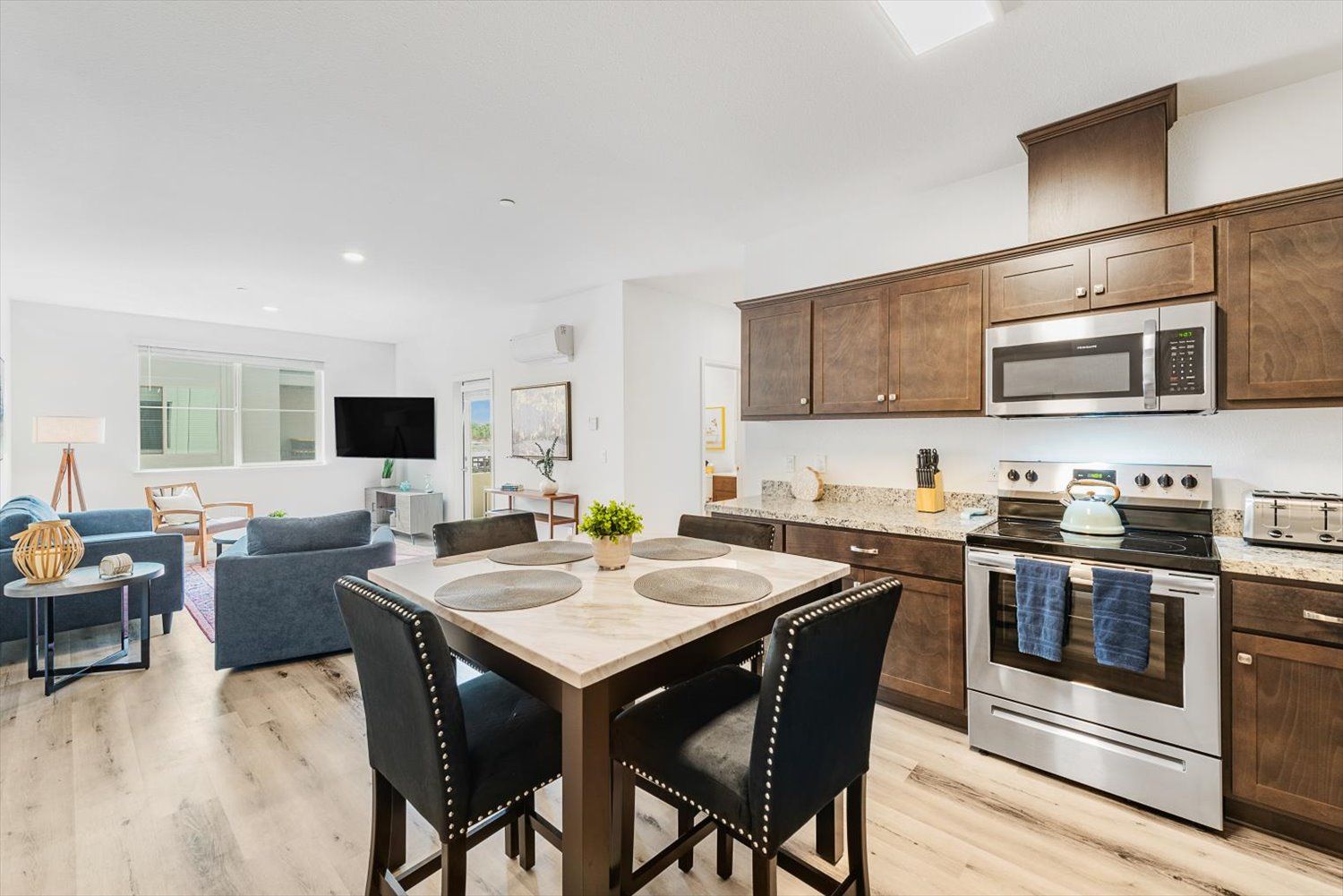 Open-concept kitchen and living area with granite countertops and stainless-steel appliances. Find the perfect balance at The Silvergate.