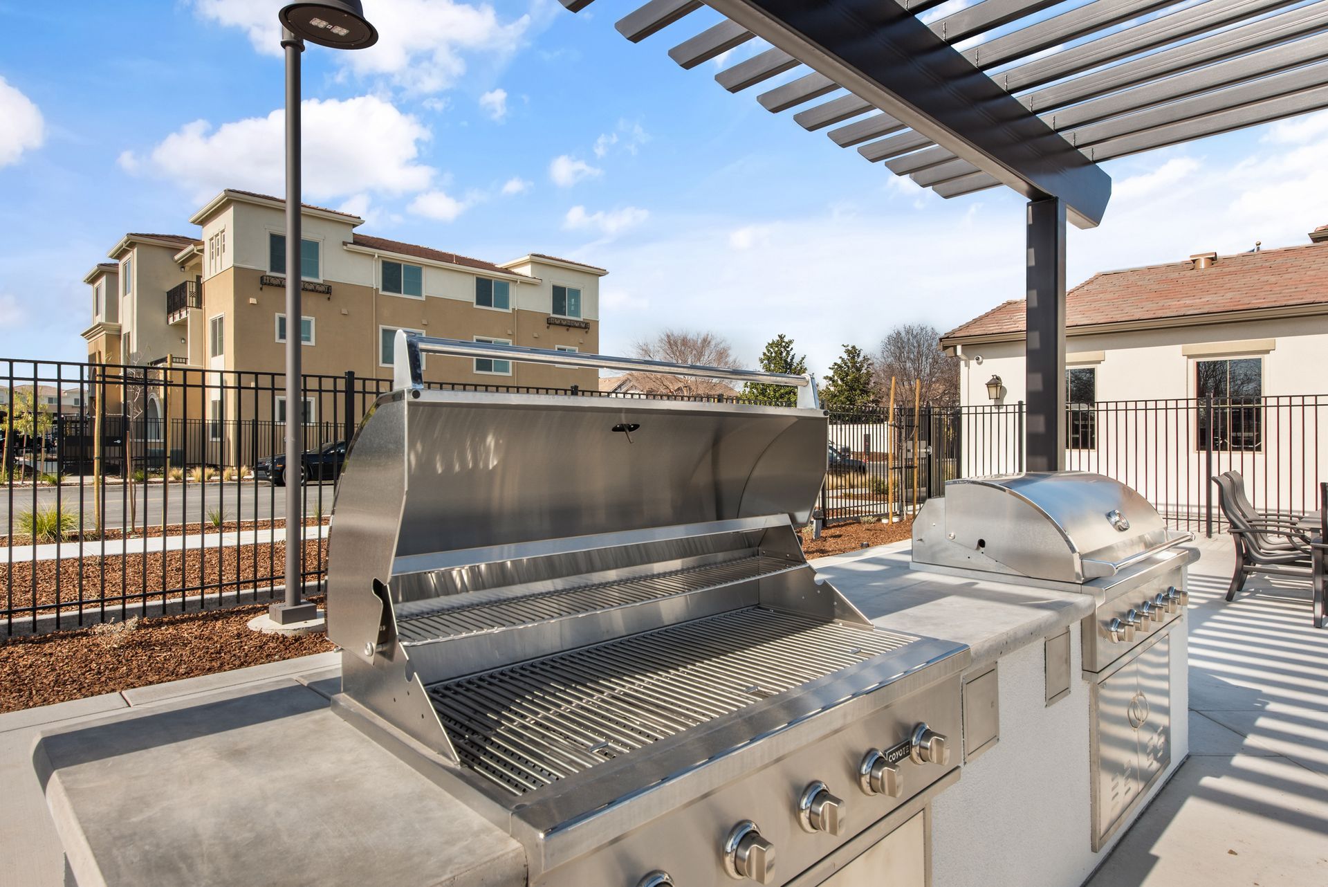 Outdoor stainless steel grill station under a pergola at an apartment community. Discover everyday ease at The Silvergate.