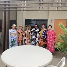 A group of women are posing for a picture in front of a table.