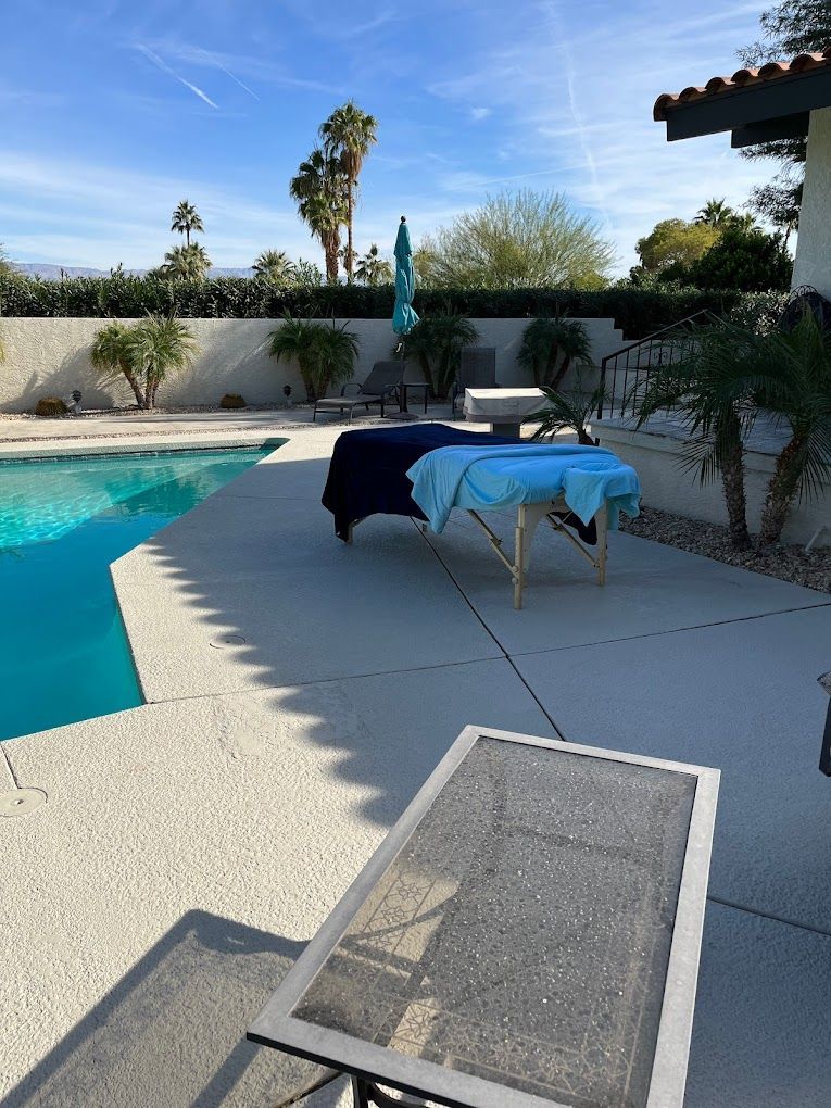 A pool with a table and chairs in front of it