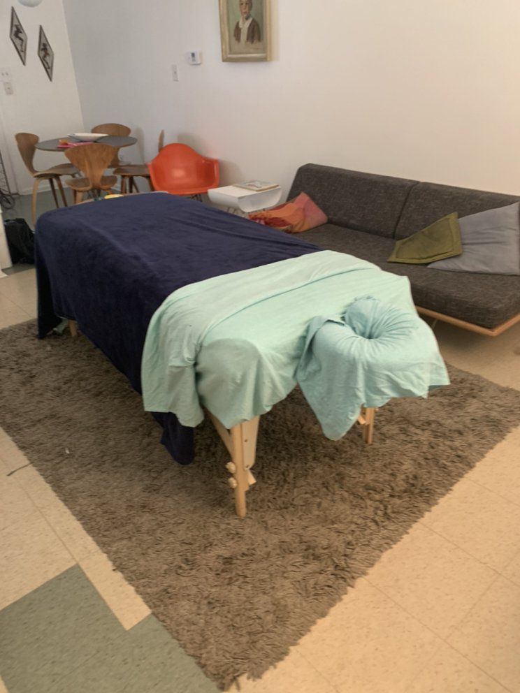 A massage table in a living room next to a couch
