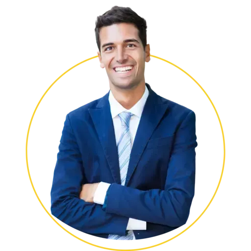 A man in a blue suit and tie is smiling with his arms crossed.