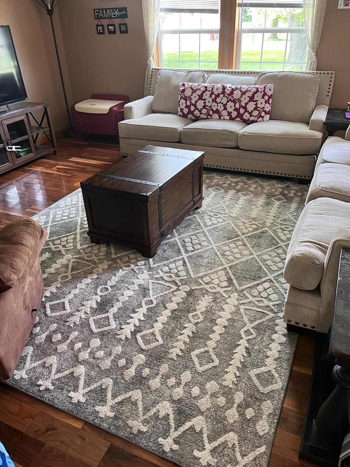 A living room filled with furniture and a rug.