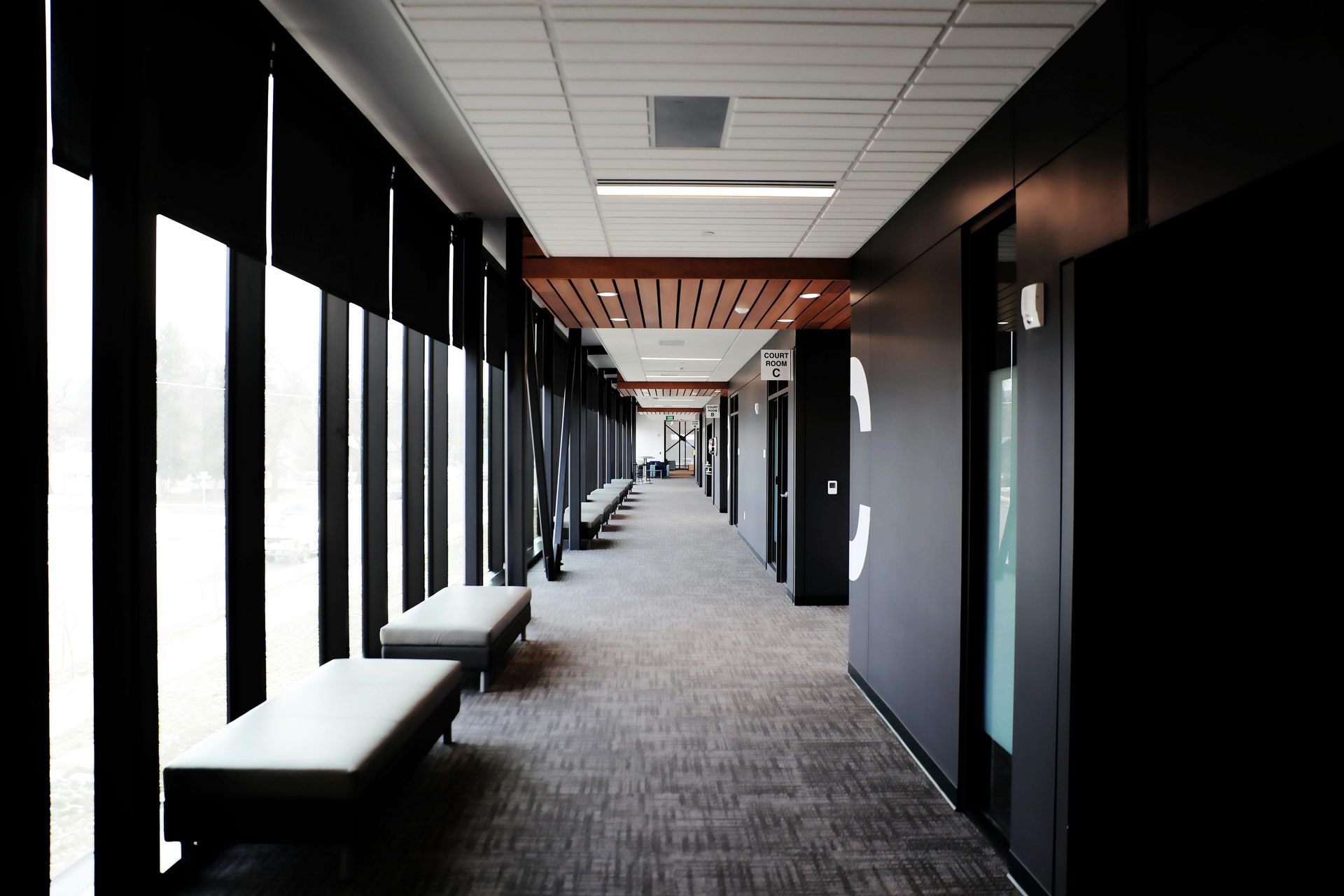 A long hallway with a lot of windows and benches