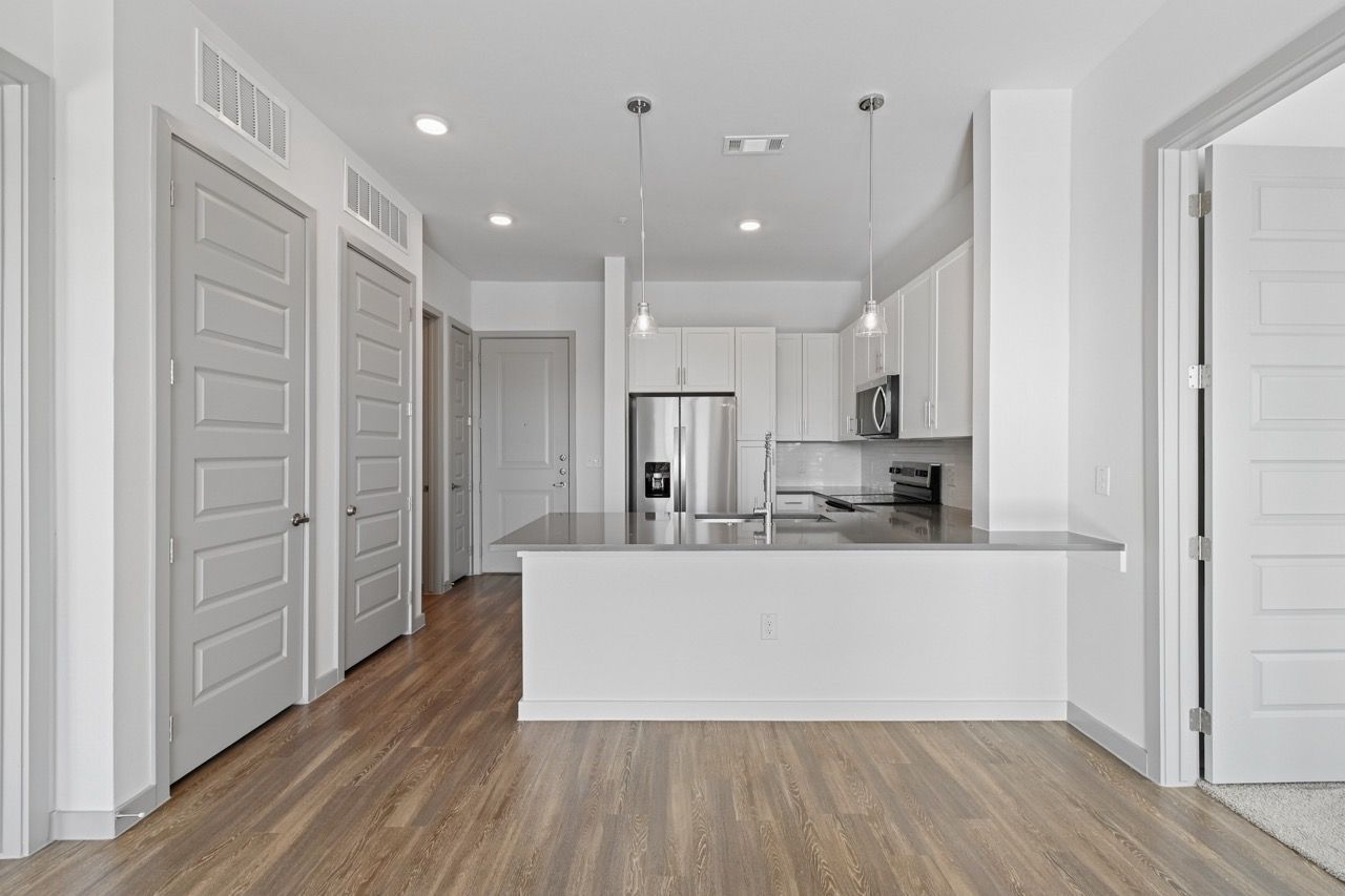 Modern apartment kitchen with island and stainless steel appliances.