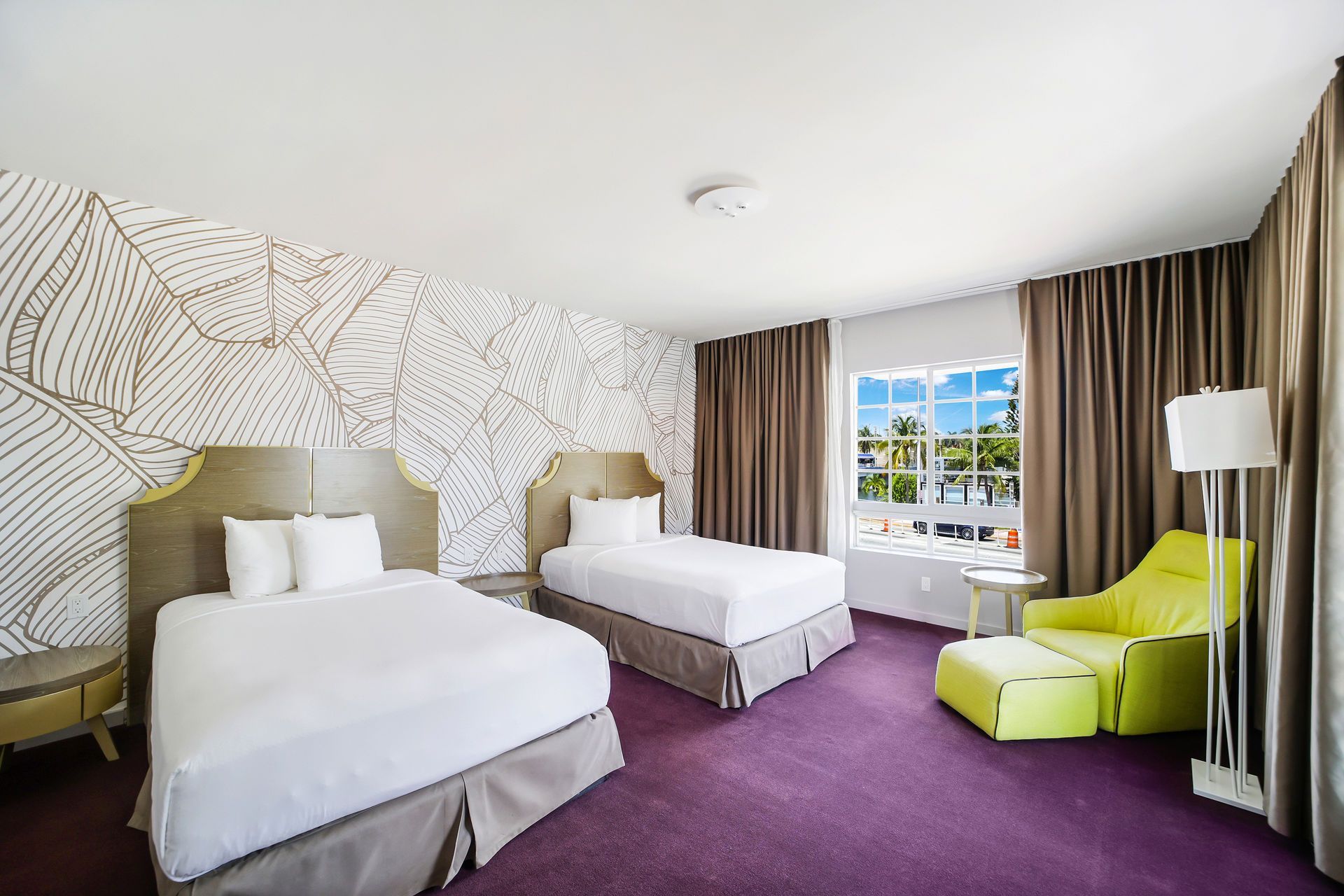 Hotel room with two twin beds, purple carpet, and a lime green chair.