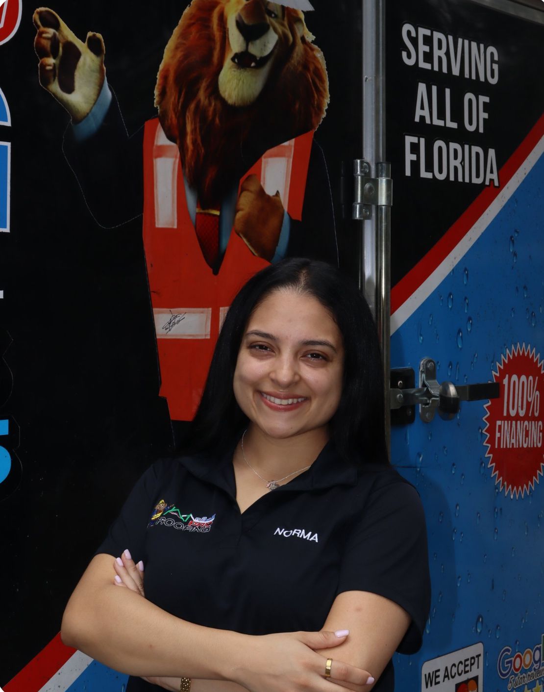 Smiling individual with long dark hair, wearing a white button-down shirt with a small logo, against a light background.