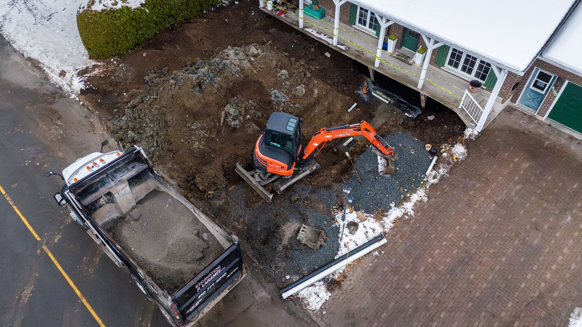 Un jardin arrière comprenant une maison grise avec une pergola en bois, un coin salon de jardin, un ensemble de salle à manger et une pelouse bien entretenue offrant une certaine intimité.