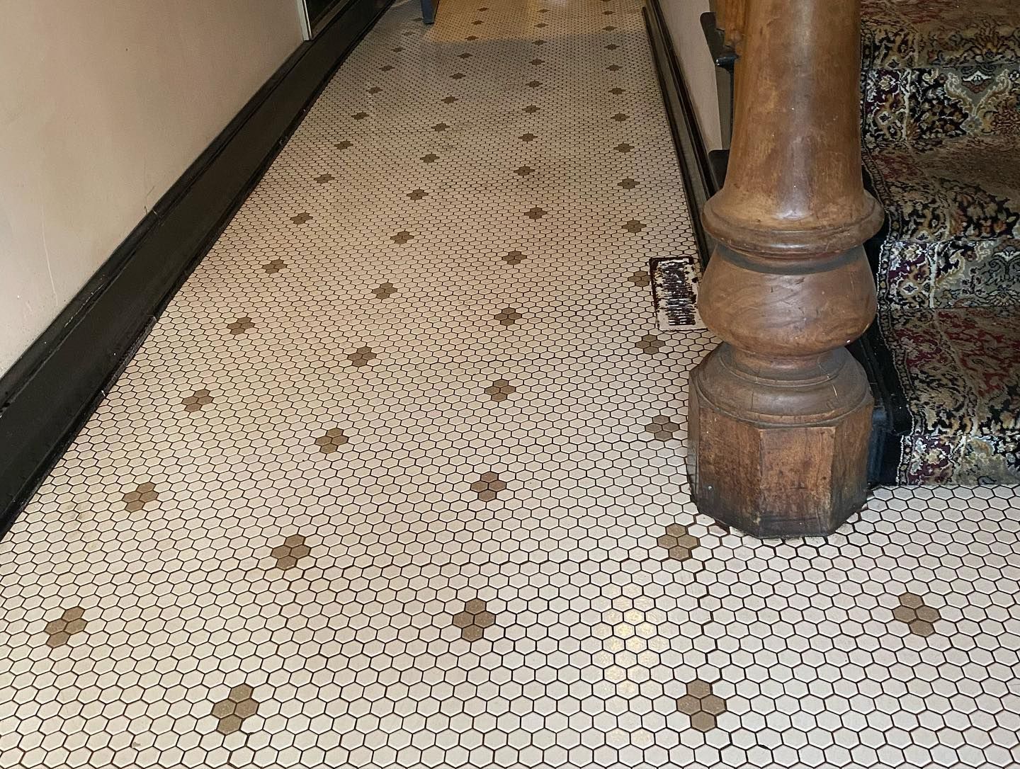 A staircase with a tiled floor and a wooden post