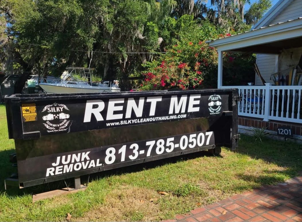 a red dumpster and a blue dumpster are sitting next to each other in a parking lot .