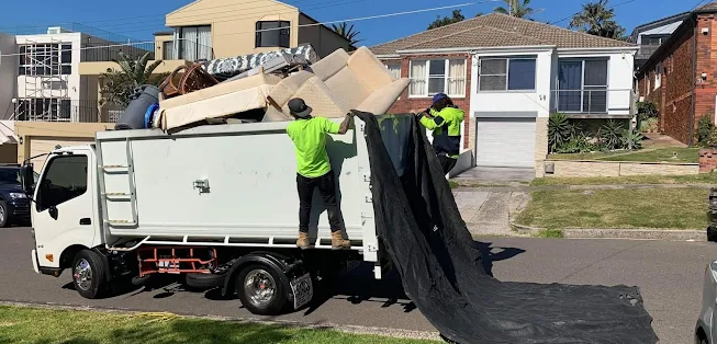 a dumpster filled with stuffed animals sits in front of a brick wall .