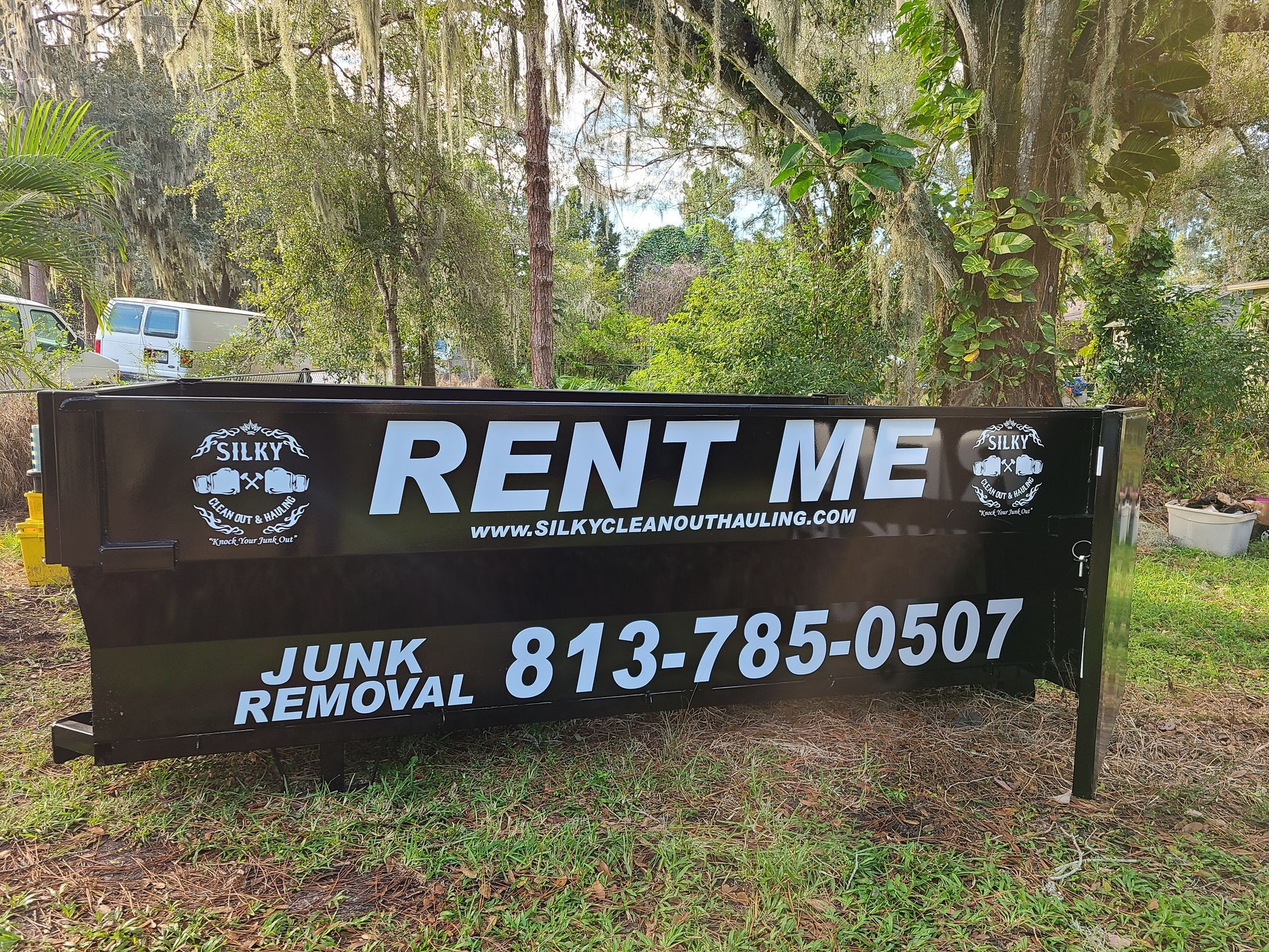 a red dumpster and a blue dumpster are sitting next to each other in a parking lot .
