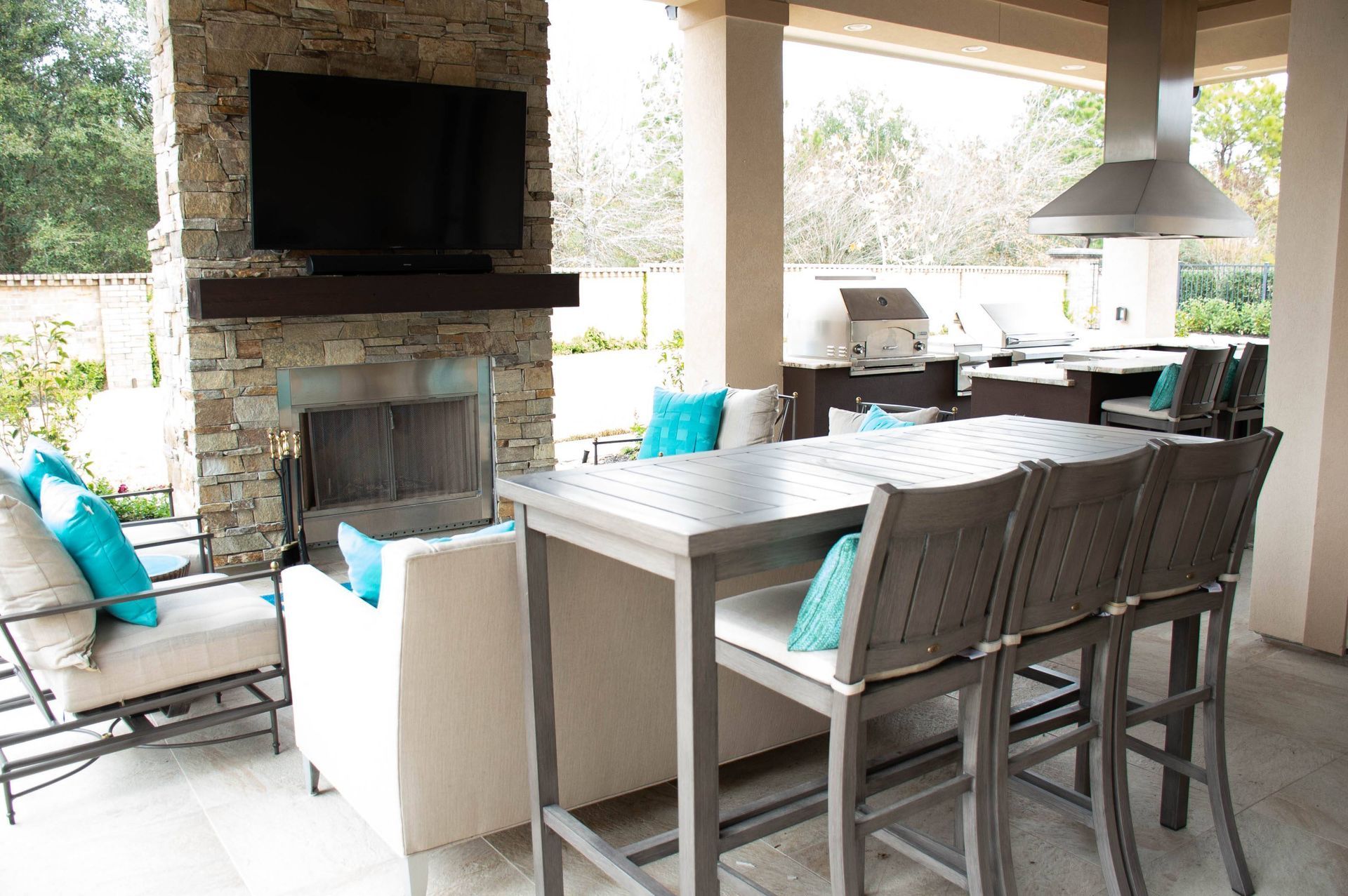 A patio with a table and chairs and a fireplace