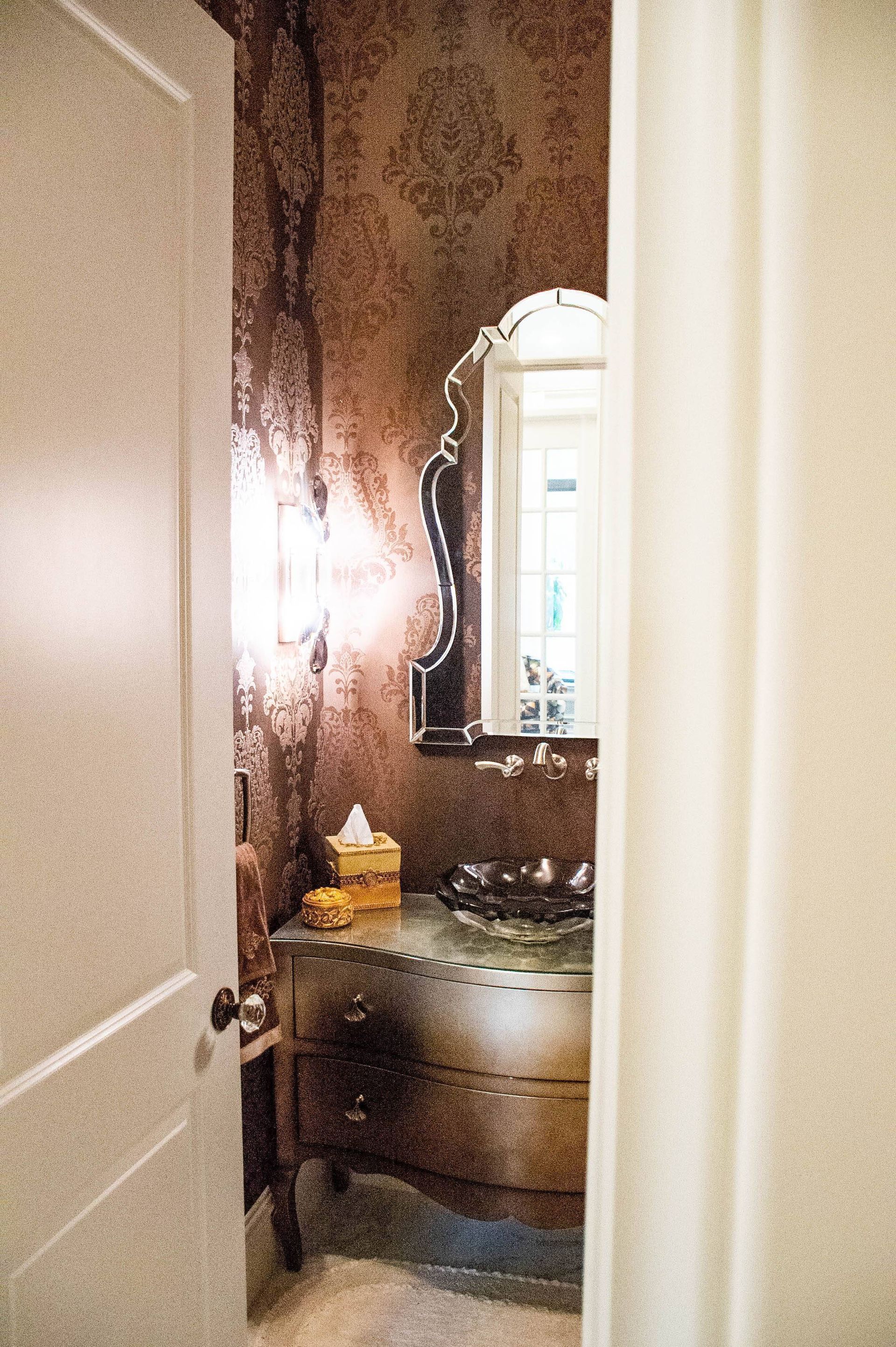 A bathroom with a sink , mirror , and tissues.