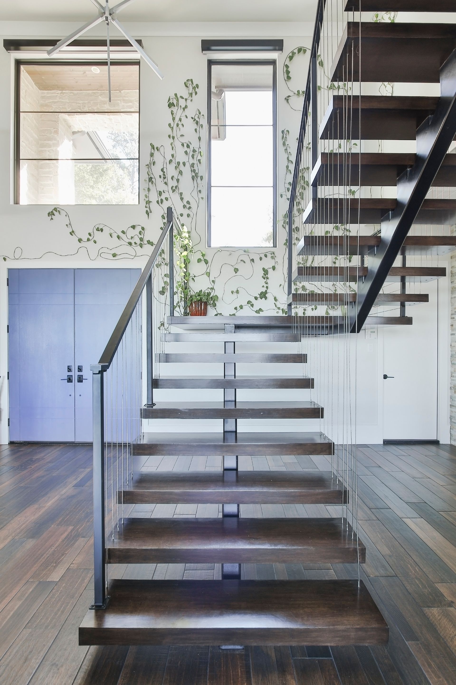 A wooden staircase with a glass railing in a house
