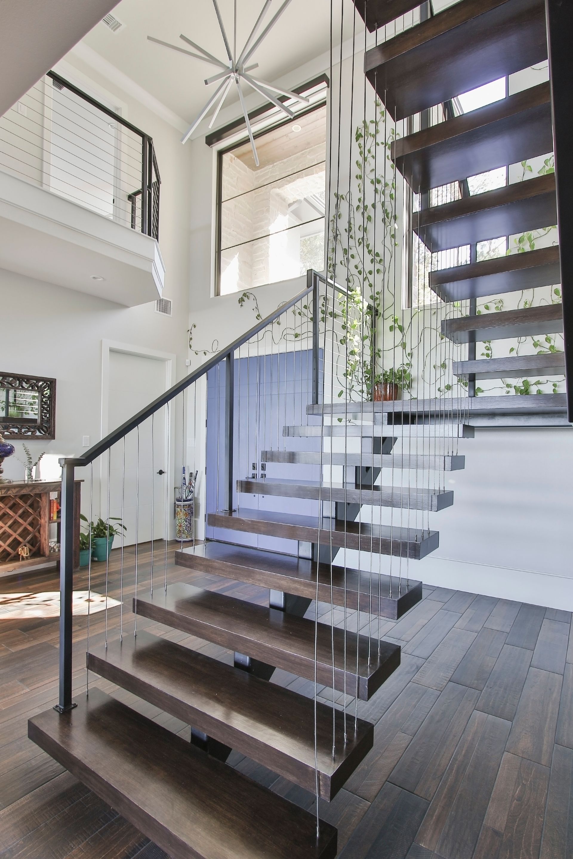 A wooden staircase with a clear railing in a house