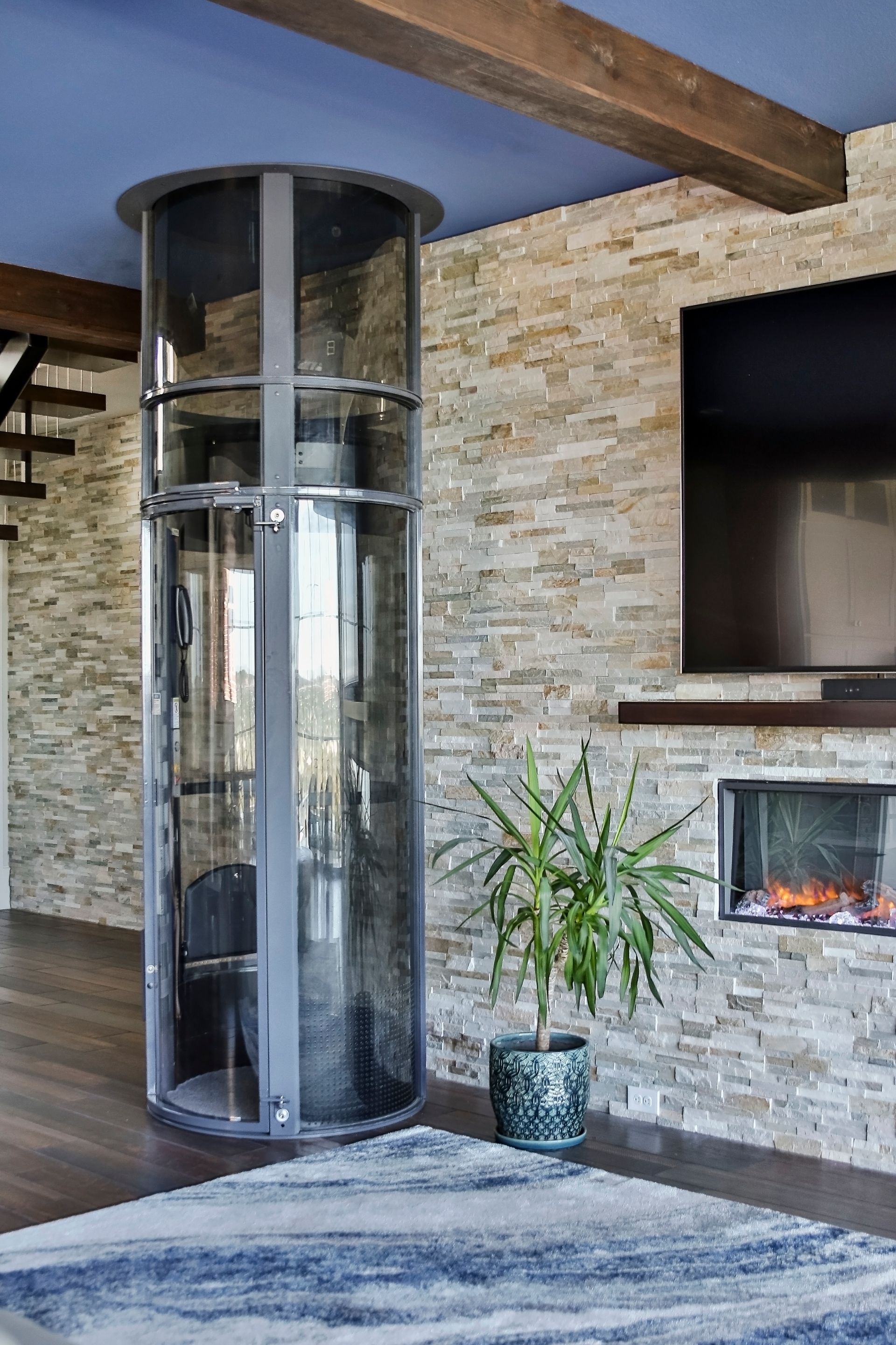 A living room with a circular elevator in the middle of the room.