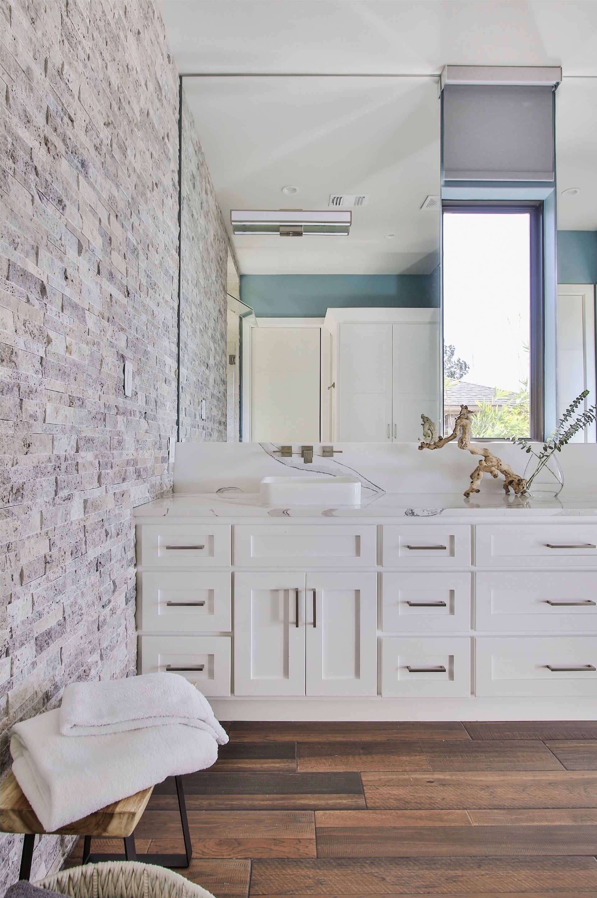 A bathroom with two sinks , a large mirror and a window.