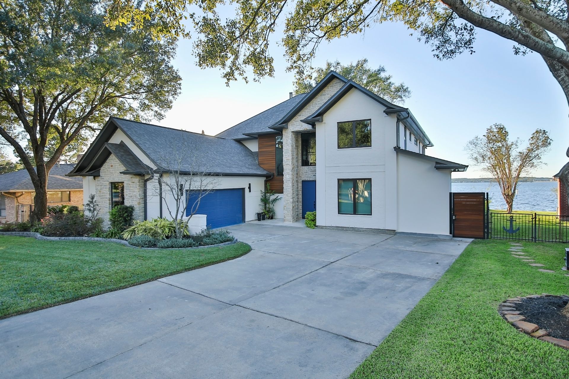 A large white house with a blue garage and a driveway