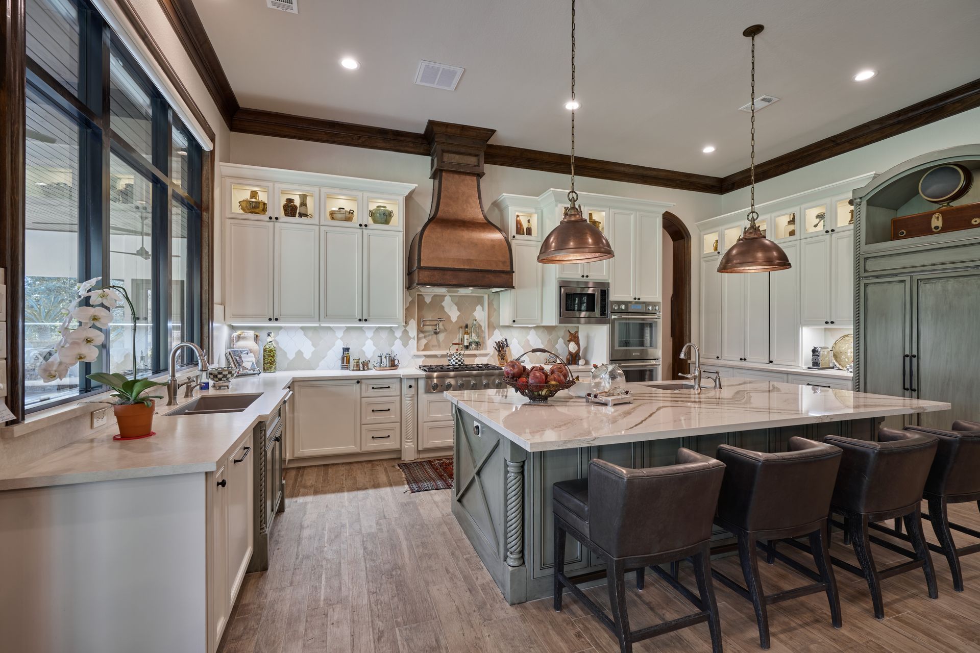 A large kitchen with white cabinets and a large island.