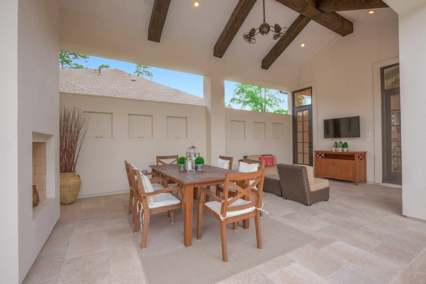 A patio with a table and chairs and a fireplace.