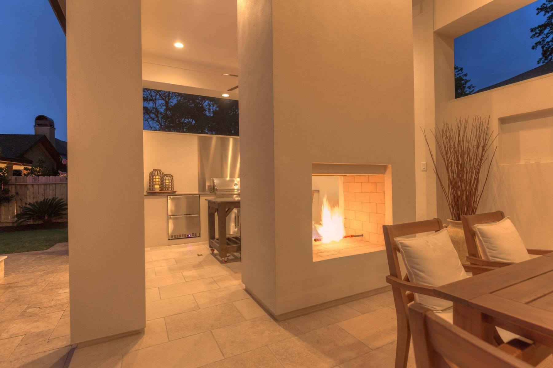 A patio with a table and chairs and a fireplace.