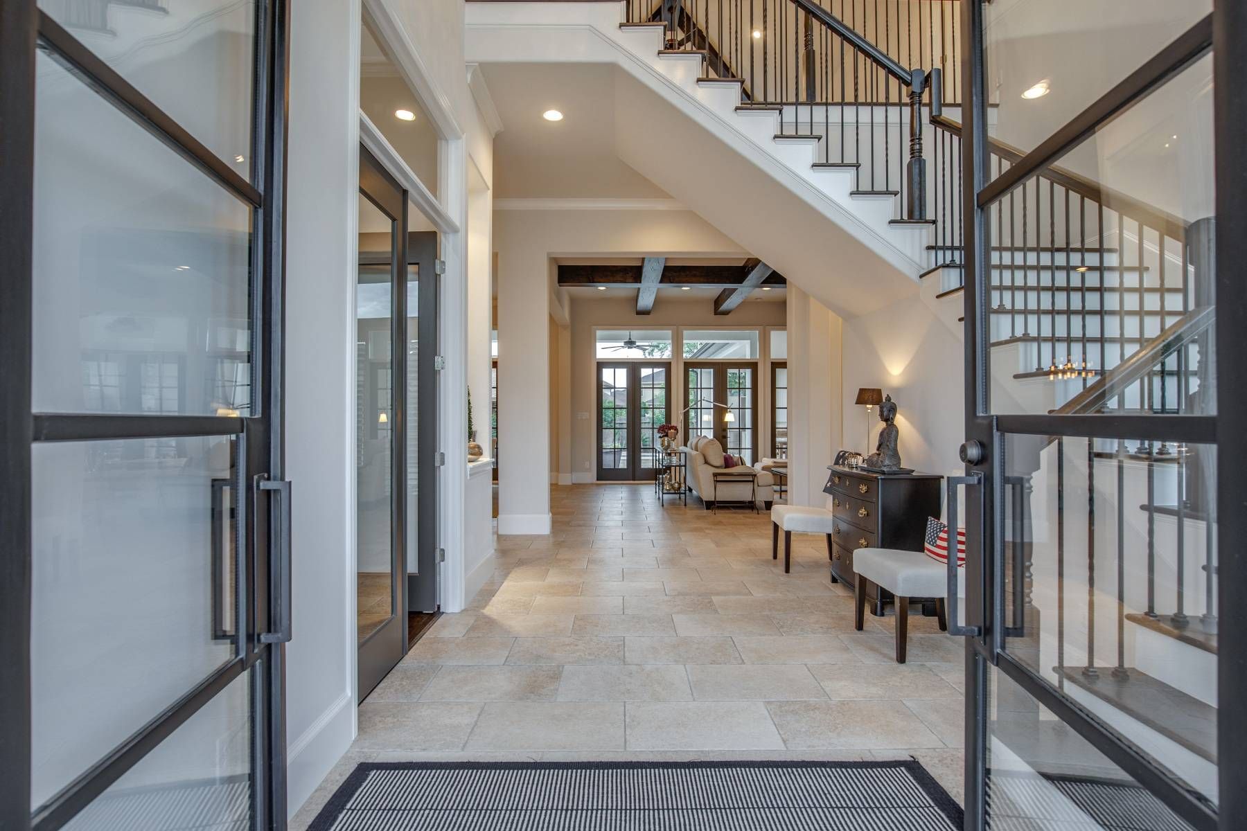 A large hallway with stairs leading up to the second floor of a house.