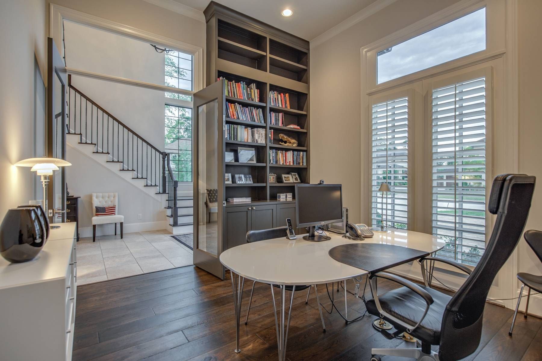 A home office with a table and chairs and a staircase in the background.