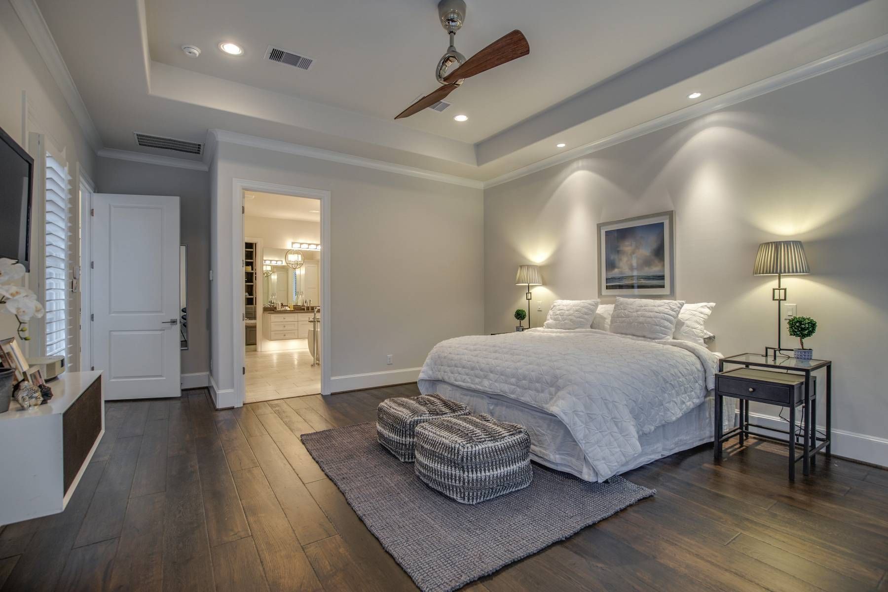 A bedroom with a large bed and a ceiling fan.