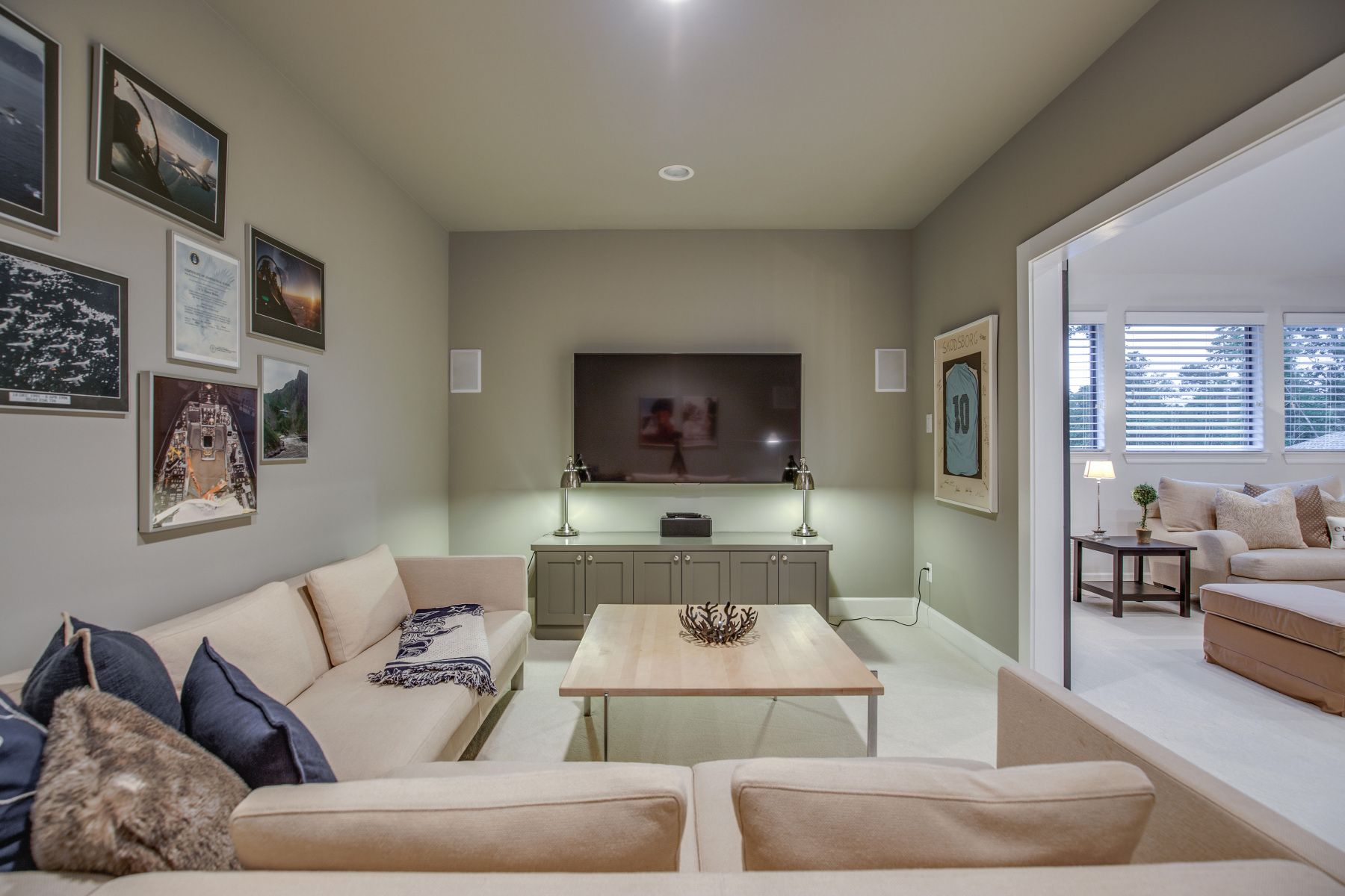 A living room with a couch and a flat screen tv on the wall.