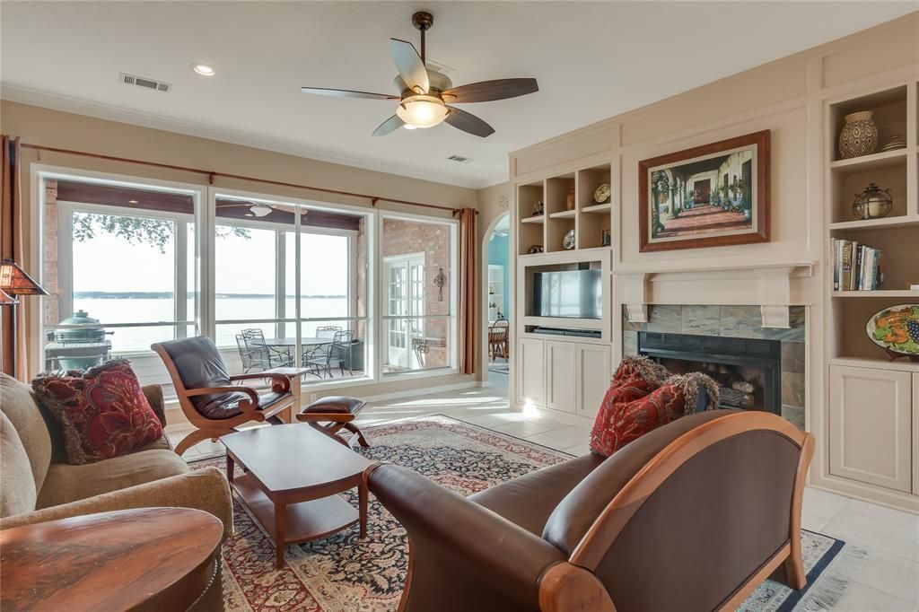 A living room with a fireplace and a ceiling fan