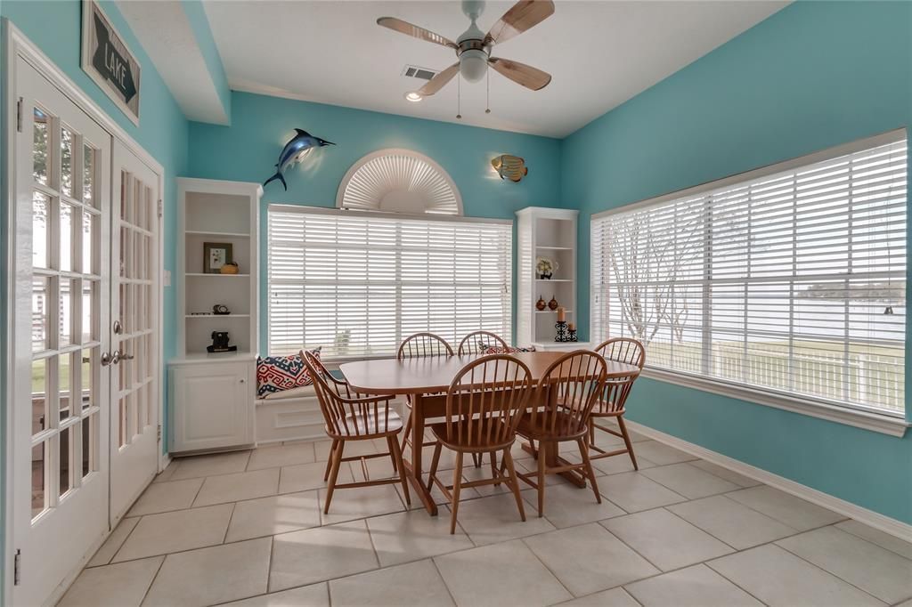 A dining room with a table and chairs and a ceiling fan