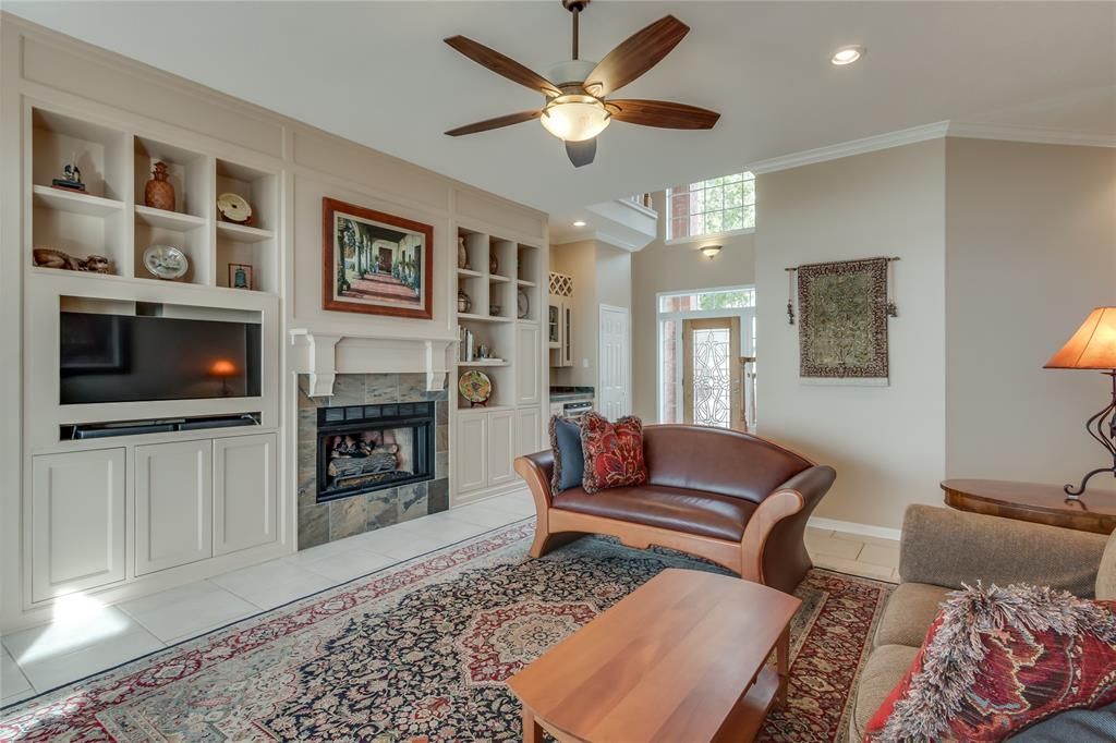 A living room with a ceiling fan and a fireplace