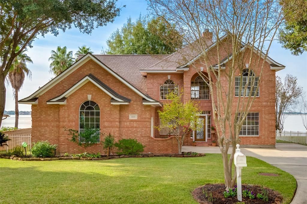 A large brick house with a large lawn and a mailbox in front of it.