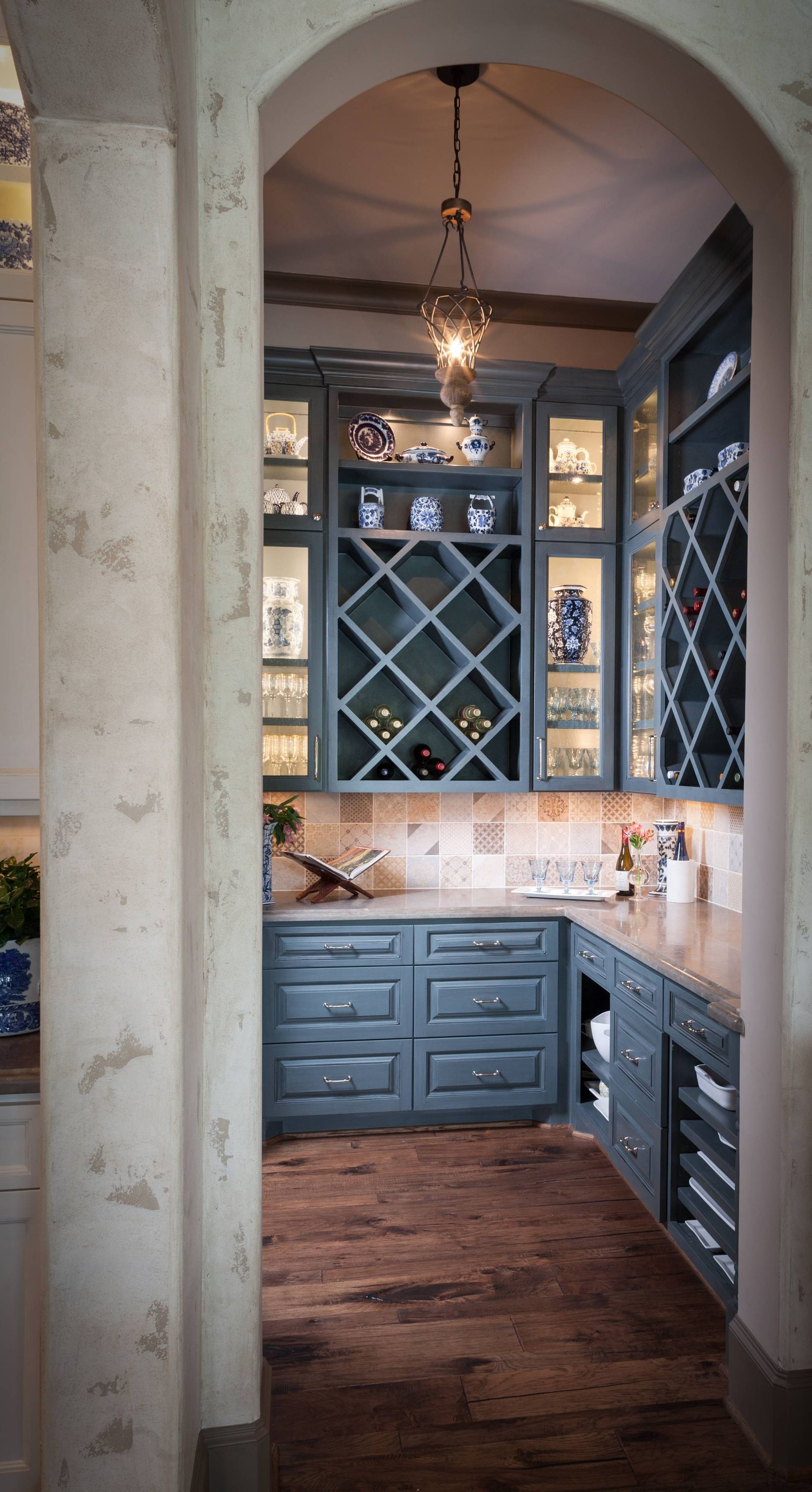 A kitchen with blue cabinets and a wine rack