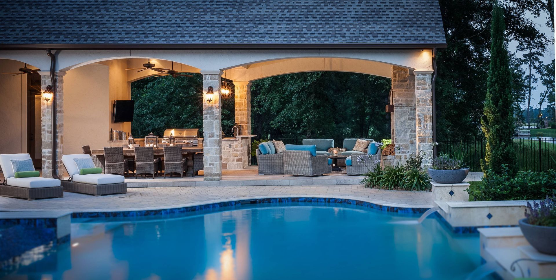 There is a large swimming pool in the backyard of a house.