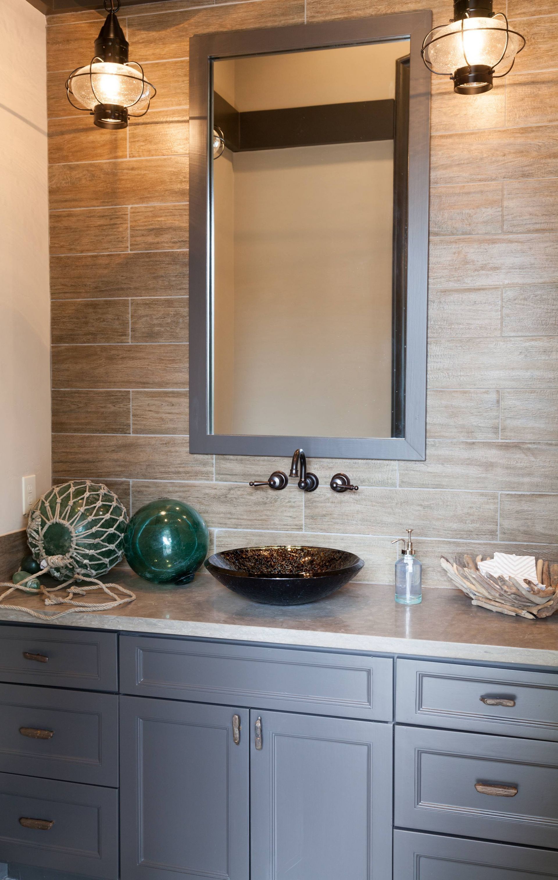 A bathroom with a sink , mirror , and cabinets.