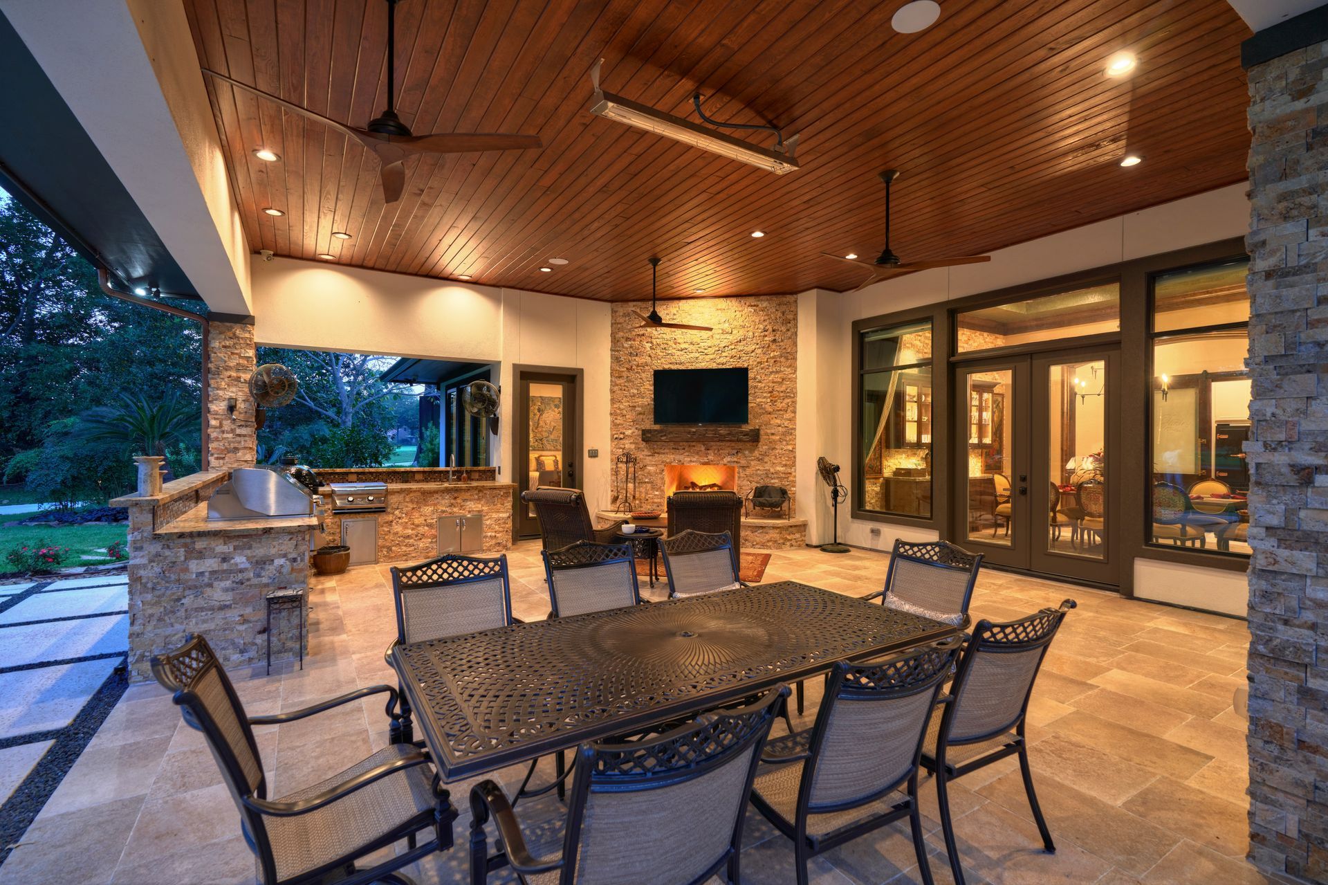 A patio with a table and chairs and a television on the wall.