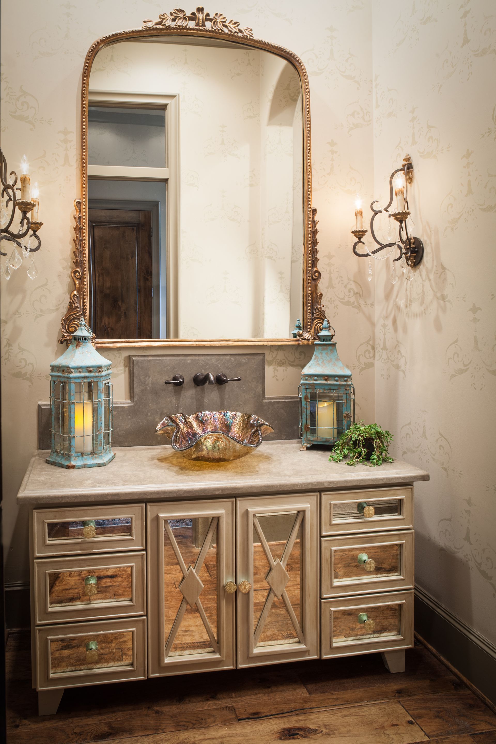 A bathroom with a sink , mirror and lanterns