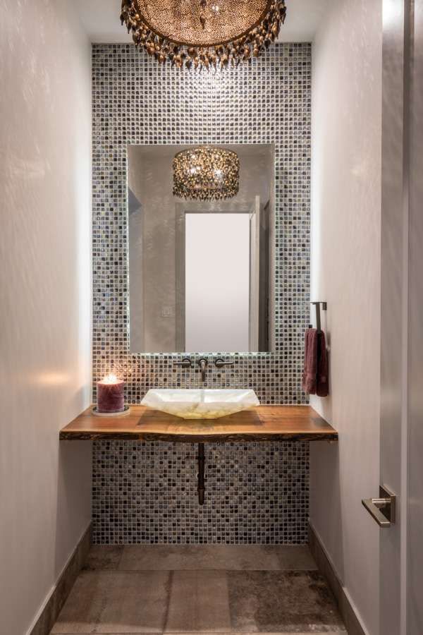 A bathroom with a sink , mirror and chandelier